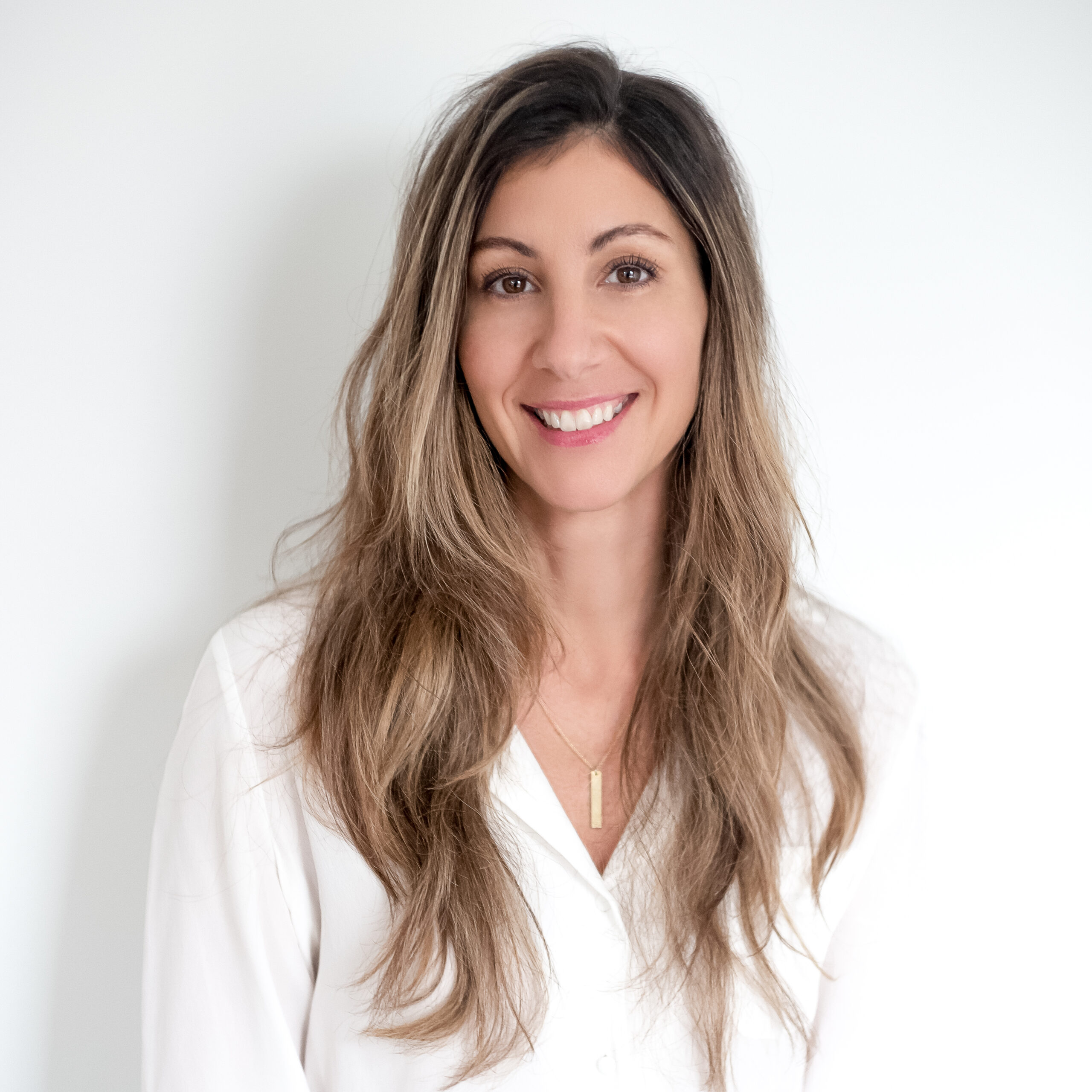 A balcony view overlooking the ocean, with gentle waves and a bright sky in the background.