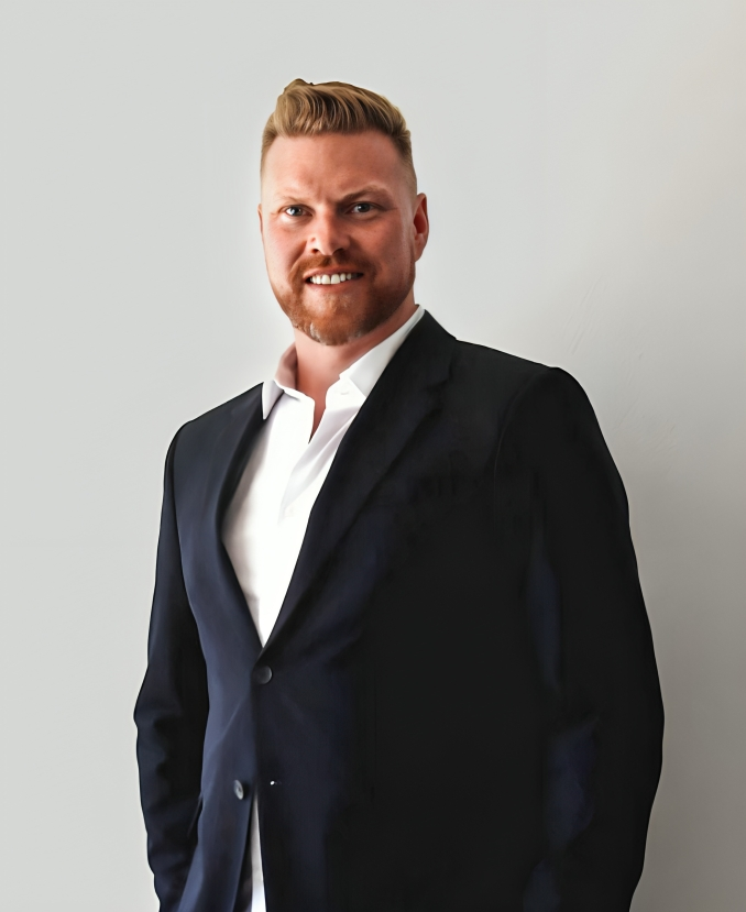 A balcony view overlooking the ocean, with gentle waves and a bright sky in the background.